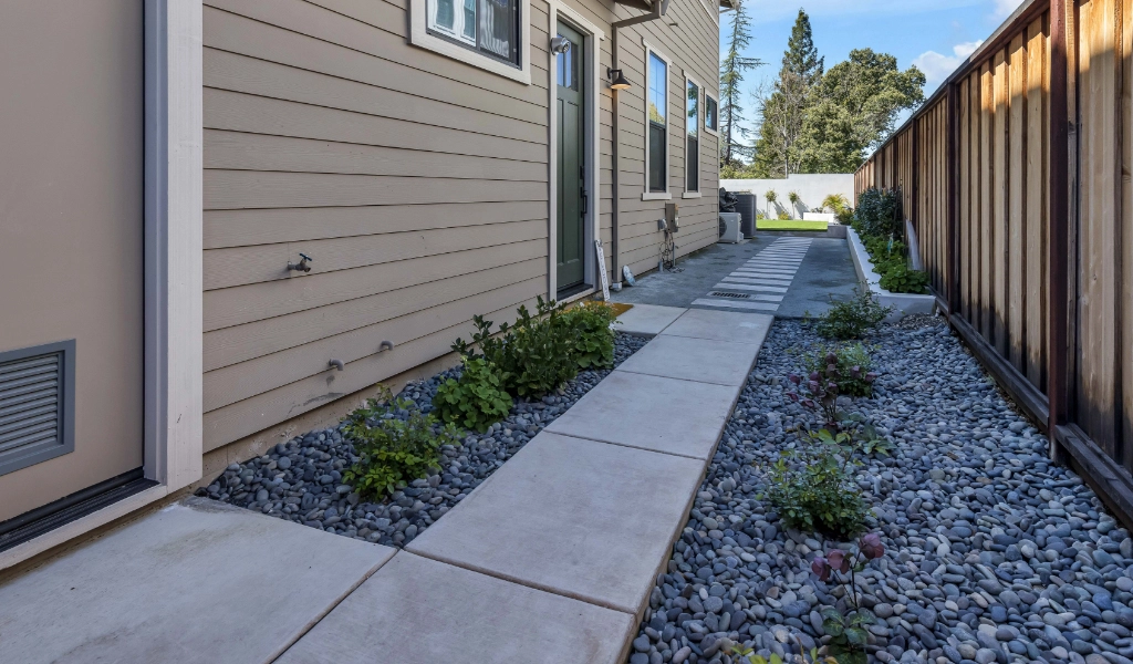 Backyard remodel with gravel and greenery.