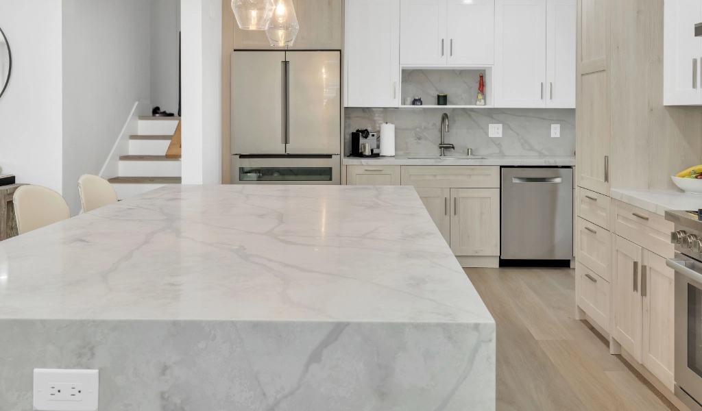 Kitchen remodel with marble countertops and new white cabinets.
