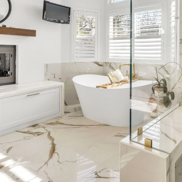 Bright and modern bathroom with a freestanding tub, walk-in shower, and a fireplace.