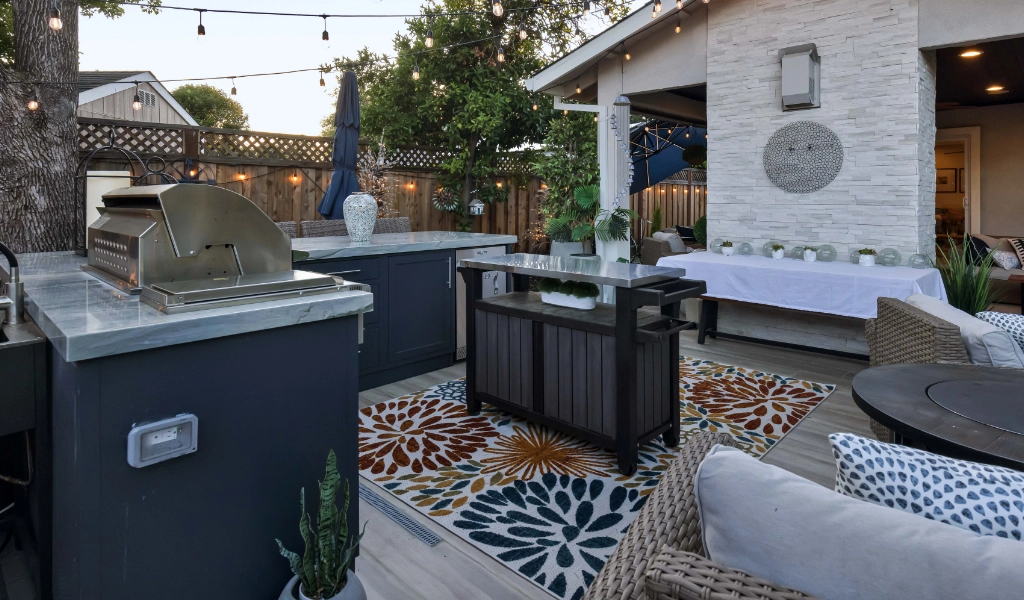 a relaxing and modern backyard living space and outdoor kitchen remodel with outdoor furniture and fireplace