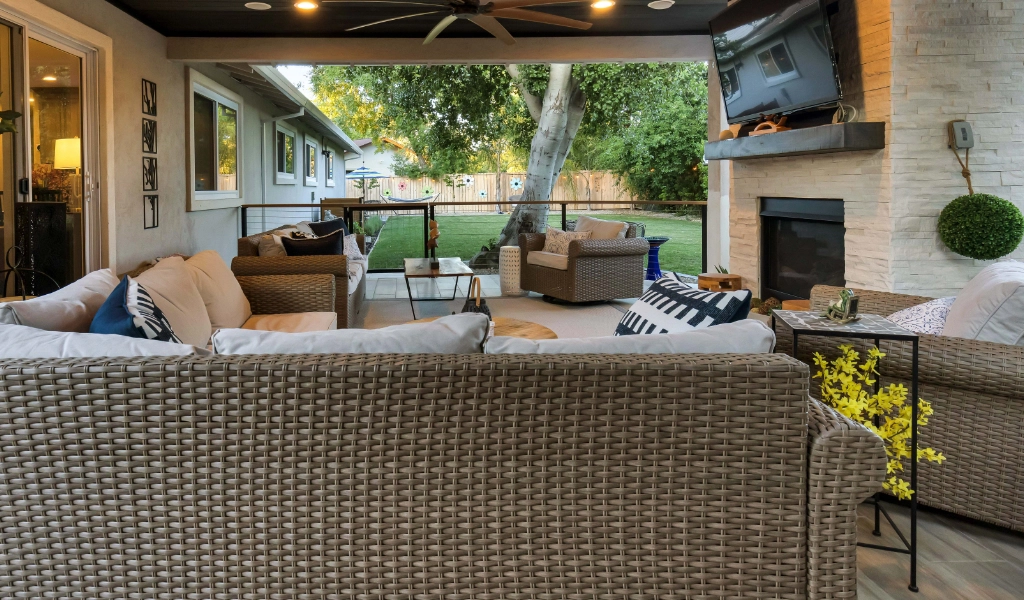 a relaxing and modern backyard living space and outdoor kitchen remodel with outdoor furniture and fireplace