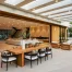 A modern outdoor living space with wood features, cozy seating, and a wooden table.